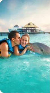 Happy family touching a dolphin on Isla Mujeres